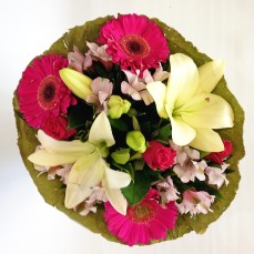 Bouquet of lilies, roses and gerberas in a lotus wrap.