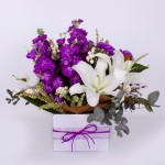 Box arrangement of purple and white flowers