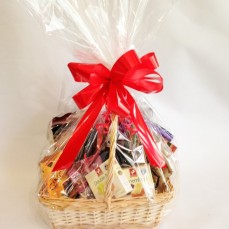Basket of treats including delicious cheeses, savoury biscuits and chocolates.